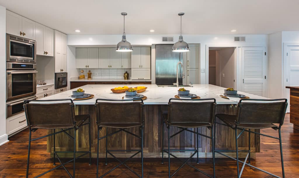 Contemporary kitchen with wooden floors and center island, illuminated by pendant lights